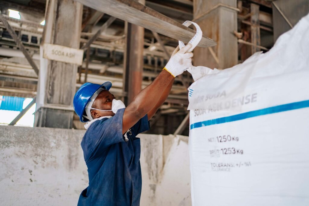 pexels photo 36423786 36423786 Industrial worker checking a large soda ash bag in a manufacturing facility.